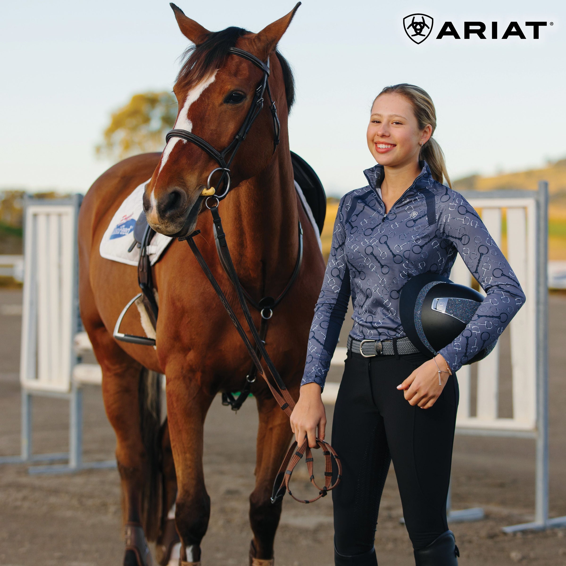 RIder with helmet under arm, standing beside horse