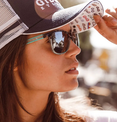Girl wearing baseball cap and sunglasses