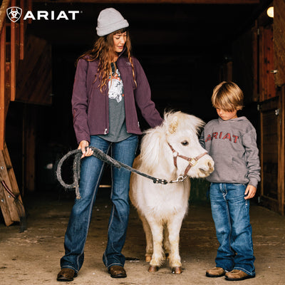 Female and young child both wearing jeans and holding a cute white pony