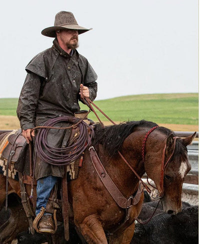 Man riding a horse wearing Oilskin coat