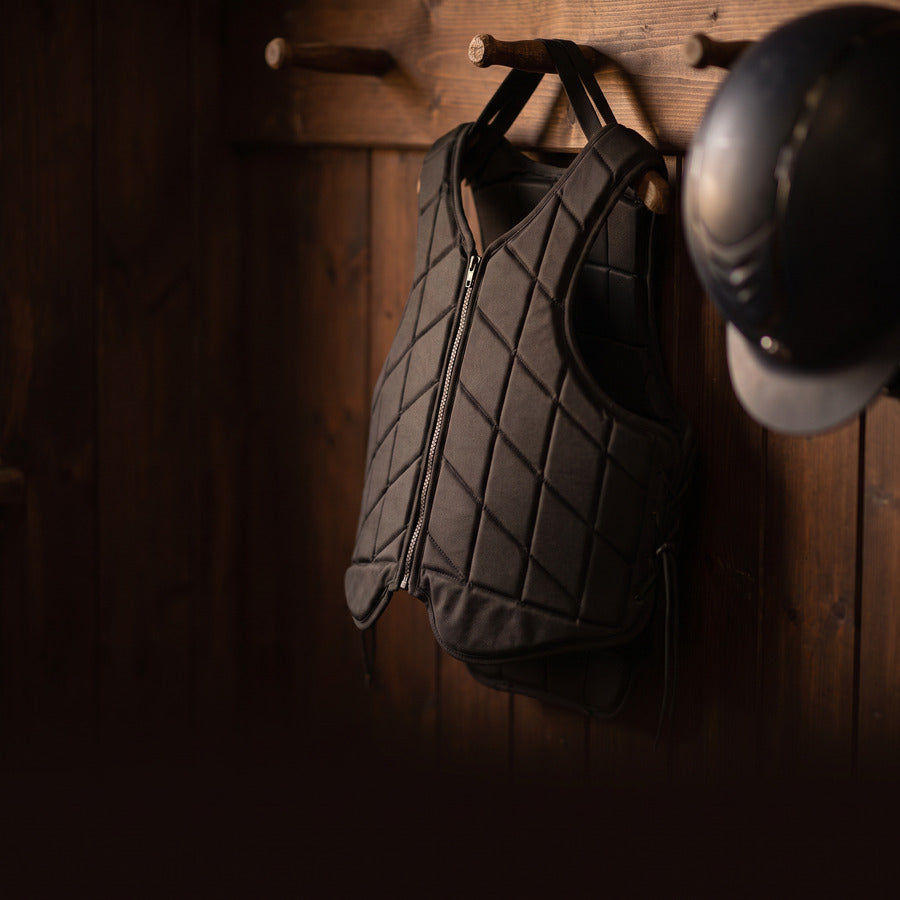 Rider's body protector and helmet hanging on a stable door